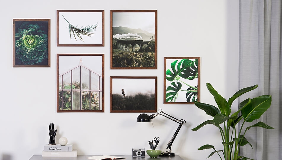 Picture wall in office - dark wooden picture frames and green nature subjects