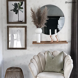 Round mirror against light wall / living room interior